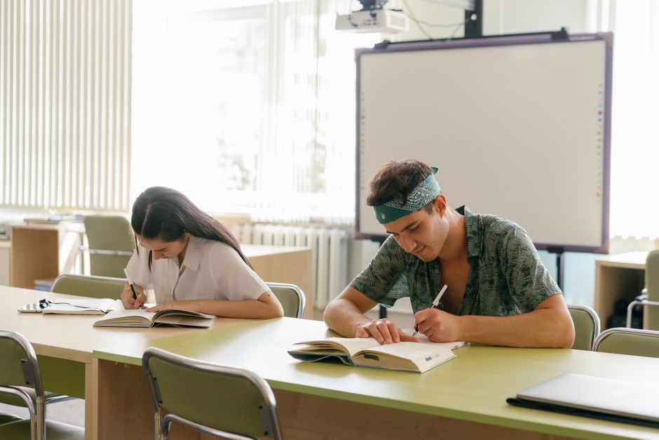 Two students focused on study in a bright, modern classroom.