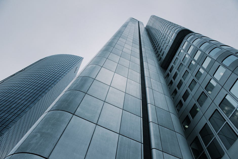 Low angle view of modern skyscrapers with glass and steel design. Perfect for corporate imagery