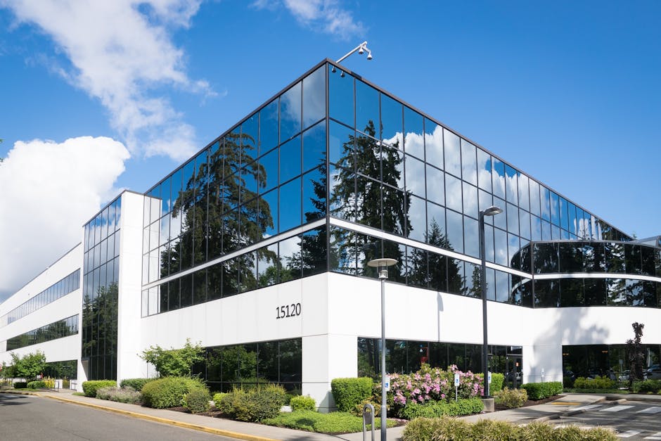 Contemporary office building in Redmond with reflective glass and lush greenery, captured on a sunny day